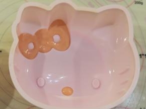 准备一个KT硅胶蛋糕模，红色蛋糕糊填充在KT的蝴蝶结和鼻子上。