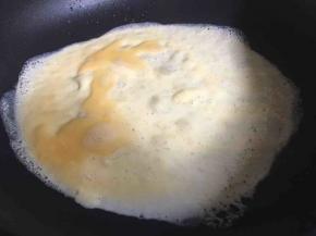 起锅刷一层薄油，倒入适量鸡蛋液，迅速转动煎锅，形成一个圆饼状，表面凝固即可；