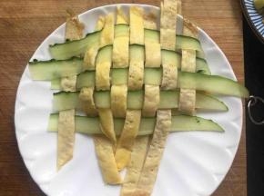 将米饭整理成紧实的圆柱形，再用刀托住面皮盖在米饭上，再用剪刀剪掉周围多余的黄瓜条、蛋皮，并整理好；