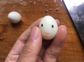 用刀在鹌鹑蛋下三分之二处割一个小口后放入胡萝卜块（尖角朝外），再将芝麻粘在其上位置；（如图示）