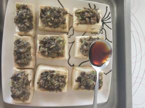 10、将辣椒碎和剩余的葱碎摆在肉馅上。淋上酱油和清水的混合物。