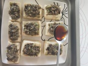 10、将辣椒碎和剩余的葱碎摆在肉馅上。淋上酱油和清水的混合物。