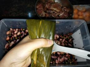 把上面的叶子往下面折下来，用手捏一下上面两个角