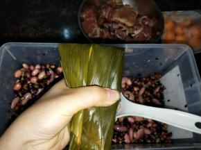 把上面的叶子往下面折下来，用手捏一下上面两个角