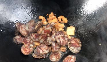 加入腊肠，煎炒至变色