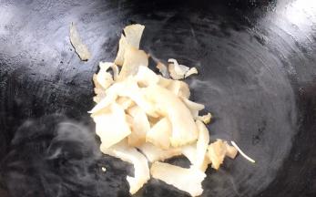 热锅无水无油，放入腊肉，煎炒至金黄色