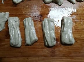 取出面团整理成长条，用保鲜膜包裹起来放入冰箱冷藏一晚，早上起来将面团分切成小长条，两头两条叠一起，用筷子在中间稍微压紧一下
