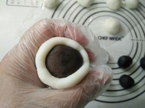 取一个糯米团包入豆沙馅搓圆。