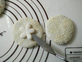 糯米团表面刷一层清水，放上刻好的花，稍微用手按压使面团粘合的更好。