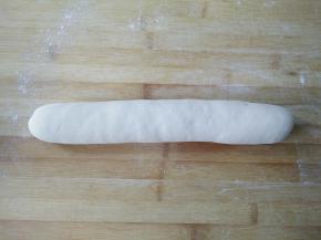 将面团放在案板上再次揉光滑，搓成长条。