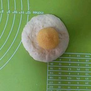 松弛完毕的面团按扁，放入椰蓉球，再包起来，接口要捏紧