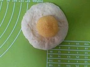 松弛完毕的面团按扁，放入椰蓉球，再包起来，接口要捏紧