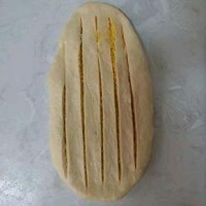 面皮移至案板上（以免划坏硅胶垫），再用锋利的小刀先中间划一刀，再左右各划两刀，两头不要划段，上下要划透