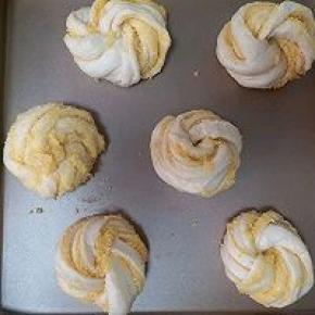 再竖着卷起来，扭成麻花再打个结，花的形状就出来了，两头都要塞进底部哦