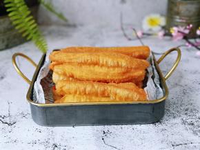 炸好的油条放在油纸上控油。