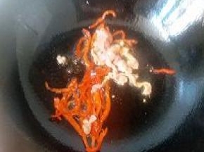锅内倒入适量油开大火烧热后关火，放入红椒丝，肉丝利用余温翻炒均匀