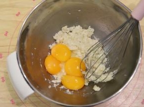 分离蛋黄和蛋清，蛋清倒入厨师机桶，放入冰箱冷冻，蛋黄磕入粉油奶混合物内。