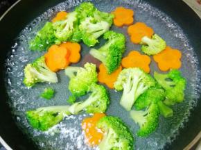 锅内烧开水加少许盐，把西兰花和胡萝卜放入锅中焯水，捞出控干水分。