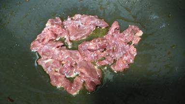 锅里热油放入牛肉片