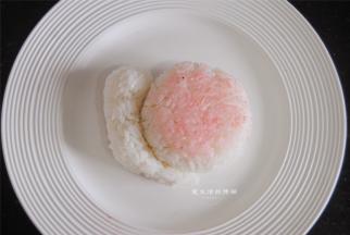 两个饭团贴合在一起，取少许草莓粉将蜗牛壳染粉红色。