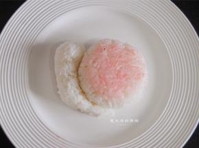 两个饭团贴合在一起，取少许草莓粉将蜗牛壳染粉红色。