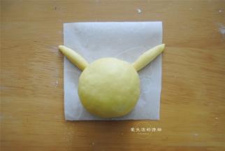 4克南瓜面团一分为二，搓长垫在脑袋下面，耳朵就做好了。