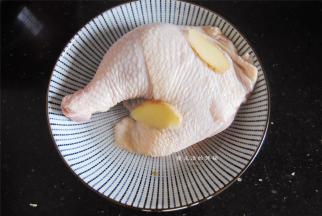 将米酒和姜片倒在鸡腿上，用手抓匀腌制20分钟去腥。