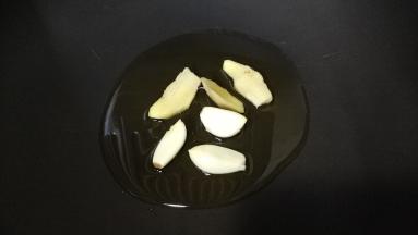 锅里热油，放入姜、蒜头煸香