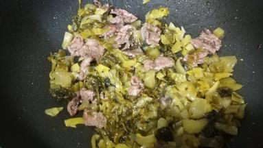 倒入酸菜炒1分钟