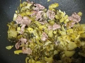 倒入酸菜炒1分钟