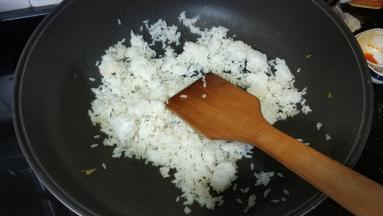锅里热油放入剩米饭炒均匀