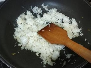 锅里热油放入剩米饭炒均匀
