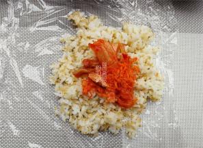 铺上保鲜膜，先取少许藜麦饭铺在保鲜膜上，再放入馅料。