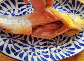 首先把黄鱼开膛破肚，刮鳞去鳃，尤其肚子里的黑膜必须清理干净，不然会很腥。