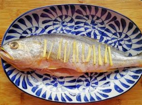 黄鱼身上划上几刀，把生姜块切点丝码入鱼身上（记住不是涂抹盐，而是放姜丝）。