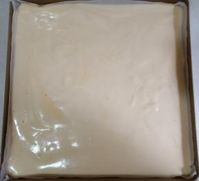 将面糊倒入提前垫好油纸的烤盘中，抹平表面，轻震模具。