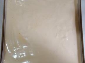 将面糊倒入提前垫好油纸的烤盘中，抹平表面，轻震模具。