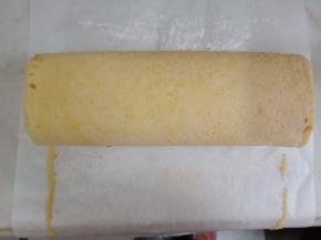 借助擀面杖将蛋糕卷起，入冰箱冷藏一小时以上定型。