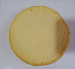 取一块蛋糕胚中间抹少许奶油，固定在蛋糕底托上，防止蛋糕胚移动。