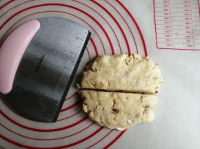 把面团放在案板上，用手压扁平一点，不需要用擀成棍，用刮板把它切成两半