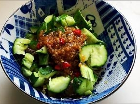 调制好的蒜泥汁浇在黄瓜海螺肉碗中。