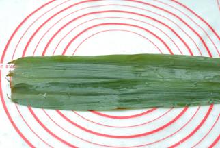 明白了粽子叶的正反方向，我们就开始包吧！先把3片叶子沾一点水，正面向上，沾水是让叶子互相之间粘连，容易包，这是包粽子的第3个小窍门。