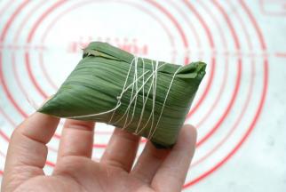 用粽子绳把它“五花大绑”就好了，我用的是家里的白线，不管什么，只要无毒无害能绑住粽子不漏米就行了。