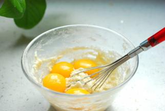 搅拌完成后把低筋面粉过筛到牛奶和玉米油的混合液中，搅拌均匀，混合到没有干面粉，然后加入蛋黄（蛋白放入另一个大一点的干净的无油无水的盆子中）。