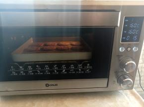 紫薯芝麻饼放入烤箱中下层，上下火160度烤15分钟，如果没有烤箱，可以放不粘锅里小火煎到两面有些发黄