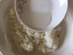 挖一碗白米饭倒入1大勺寿司醋拌匀。
