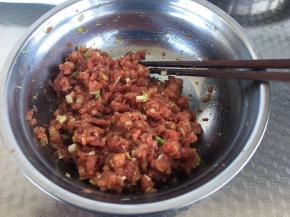 把肉剁碎，葱切碎加入调料（酱油、盐、耗油、花椒粉、少许油）按一个方向搅拌均匀备用