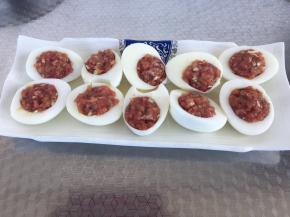 把去皮的鸡蛋顺长在中间一切两半。把鸡蛋中的蛋黄取出，将调好的肉馅装到蛋清中，要装满压实。