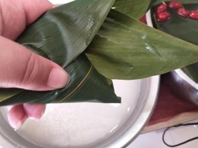 摆上2个大枣，然后掐住2边，盖上封口，顺着方向包严实。