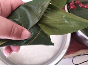 摆上2个大枣，然后掐住2边，盖上封口，顺着方向包严实。
